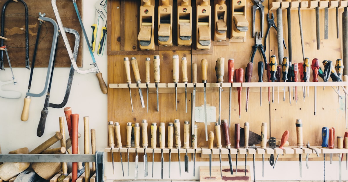 Assorted hand tools and maker gear on a workshop rack