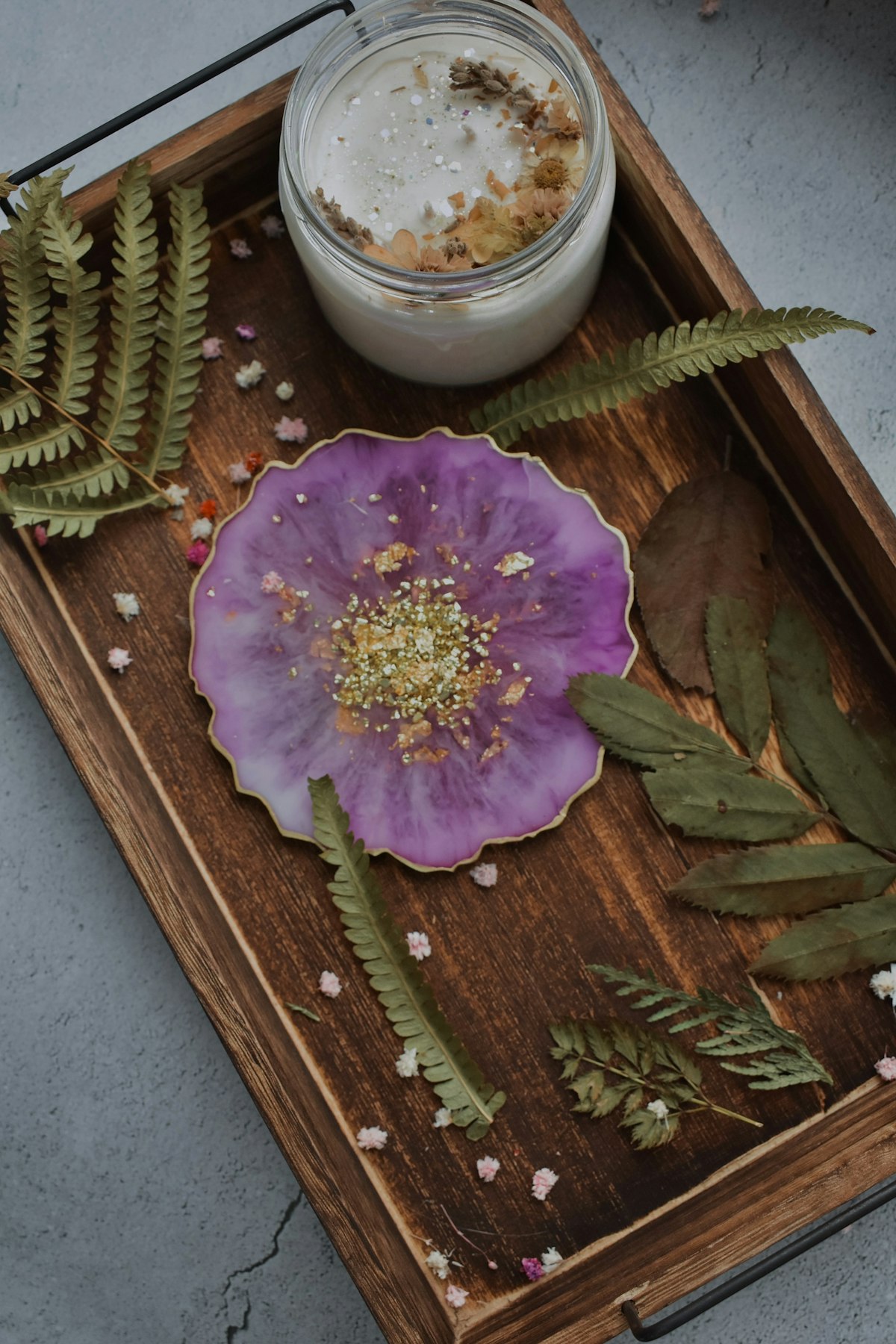 Epoxy resin art supplies and completed resin crafts on a wooden workbench