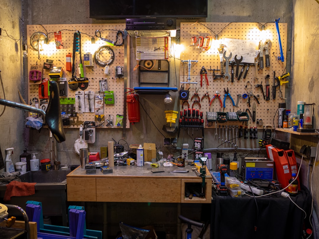 Hand tools and a tool kit laid out on a workshop wall bench with a workbench below