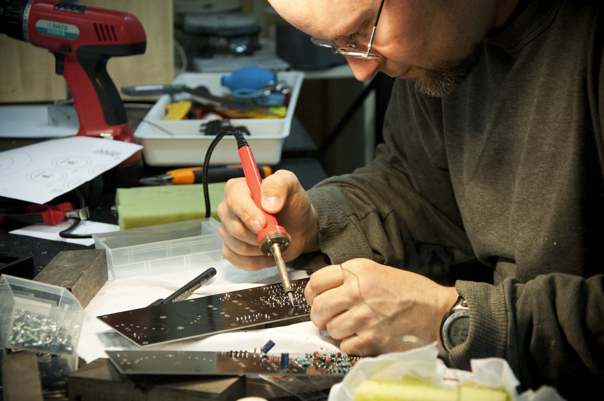 Technician repairing a circuit board with a soldering iron