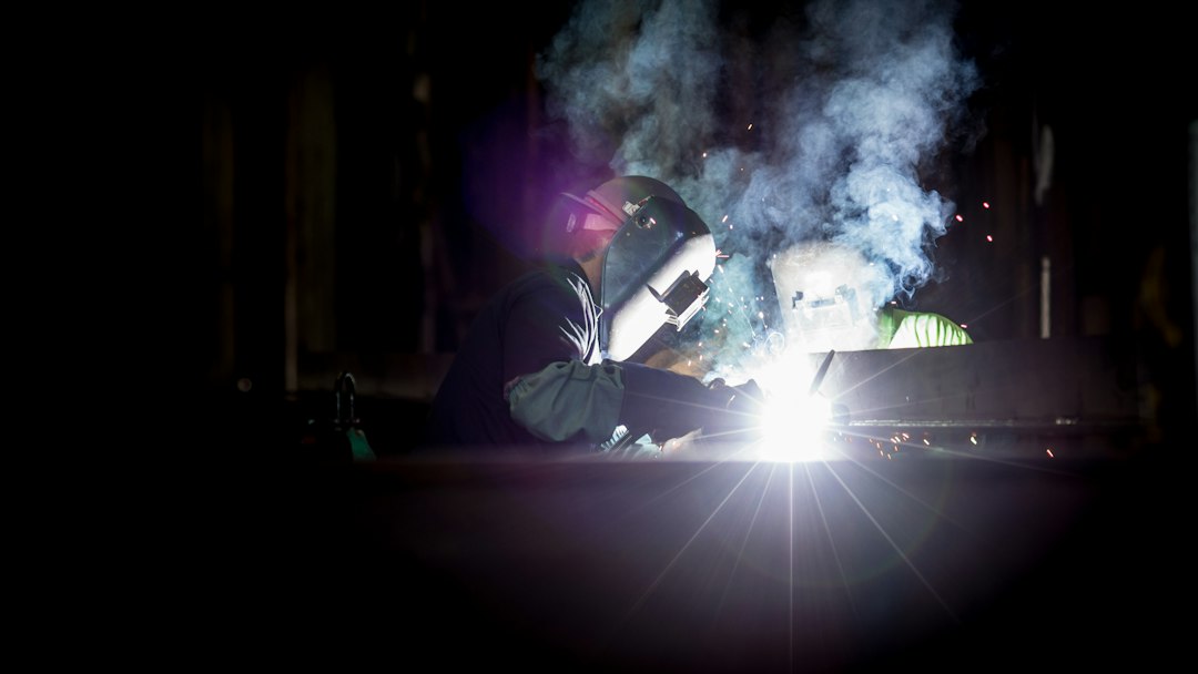 Two welders working on metal in a workshop