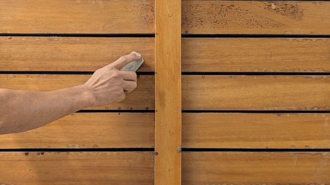 Hand sanding a wooden plank smooth in a home workshop